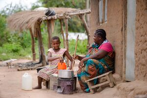 Nura Chuol prepares a food using an improved eco-friendly cook stove with her daughter Nyakong Chuol at their home at Siripi, Odupi Sub-County in Terego District on October 1, 2021.